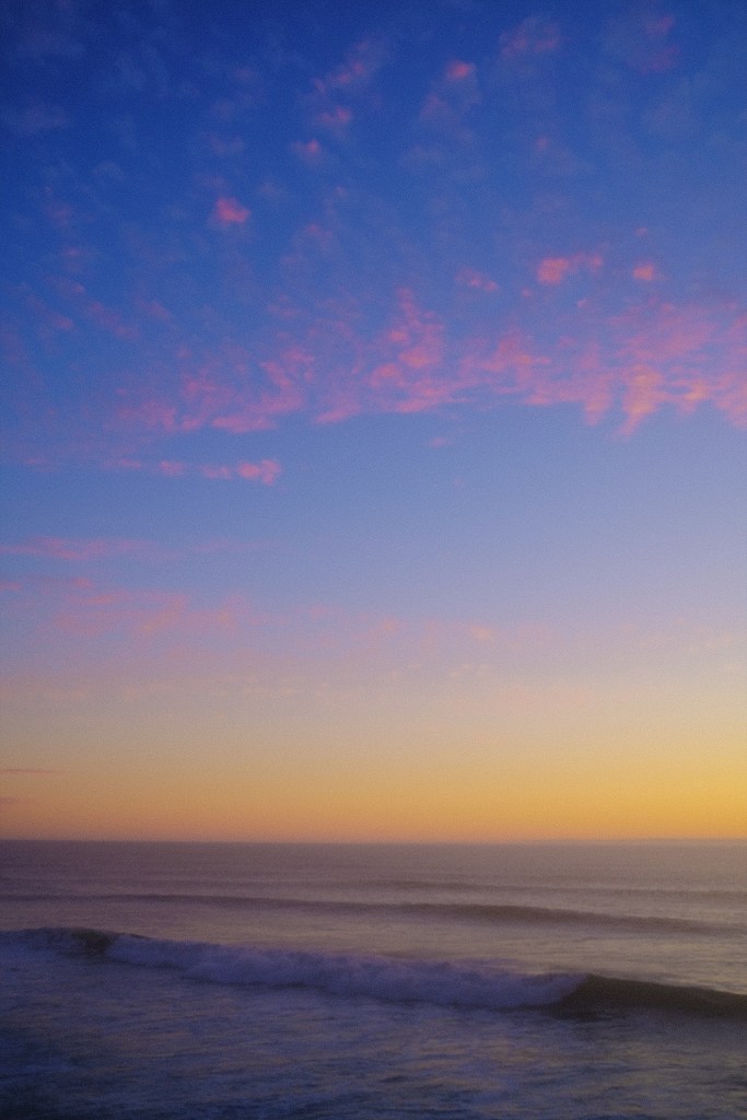 San Francisco sunset with pink clouds over waves